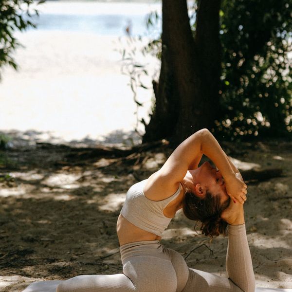 Person stretching outdoors with the sun setting behind them.